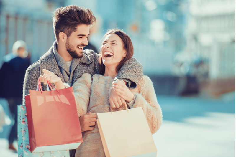 A joyful young couple smiles while shopping in Leavenworth, WA.