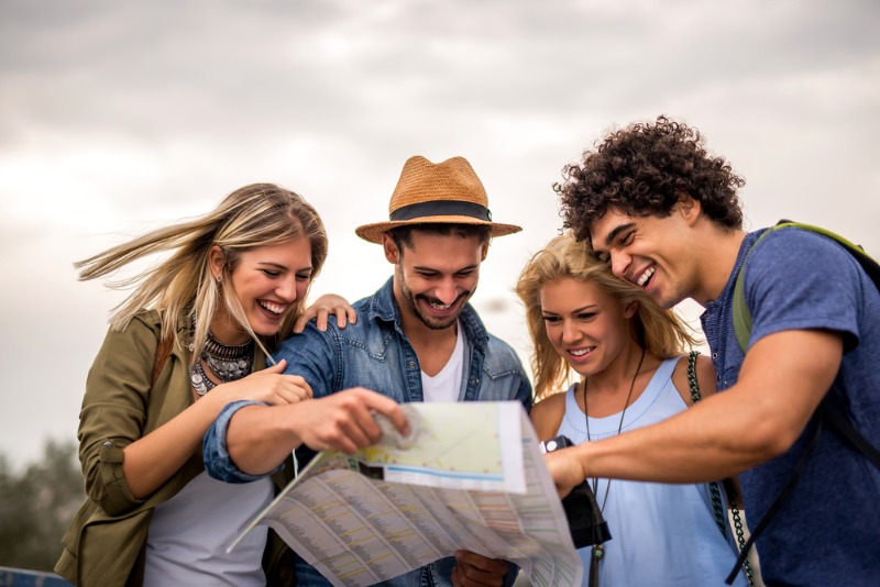 A group of young adults gleefully examine their map while engaging in a self-guided tour of Leavenworth, WA.