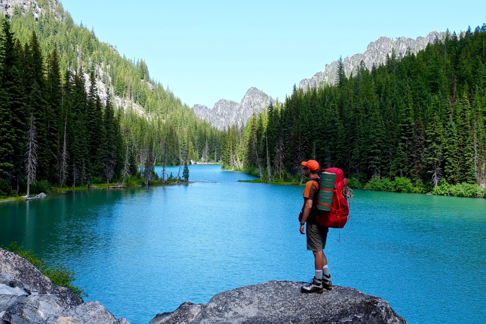 Washington State Bucket List: A solo hiker gazes in awe at a stunning mountain landscape outside of Leavenworth, WA.